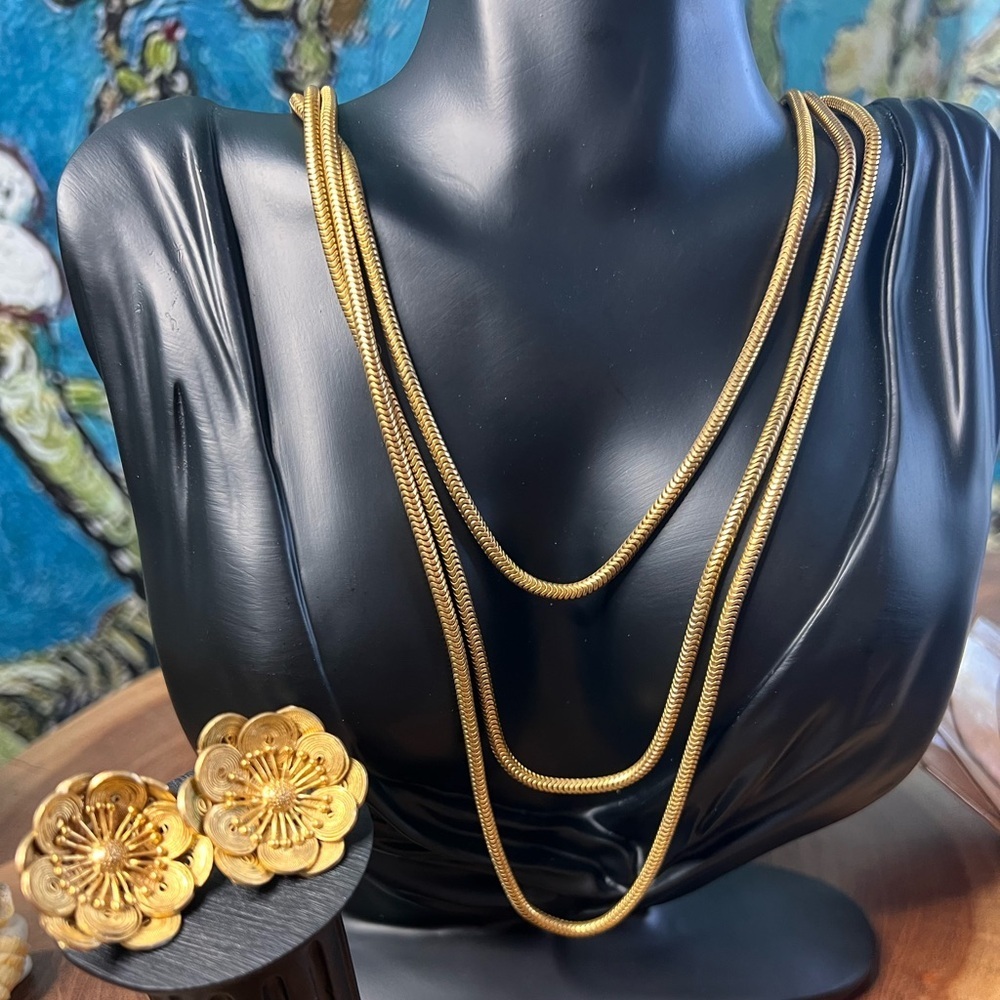 Gold, three strand, necklace with ornate, gold flower, clip on earrings.